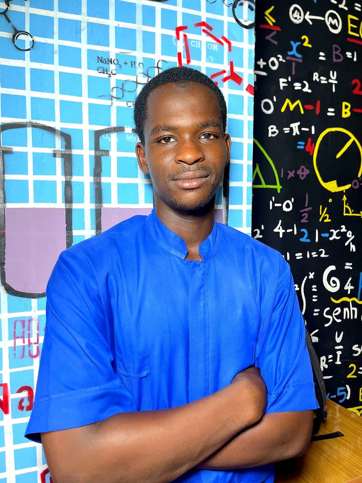 Student in blue scrubs, arms folded