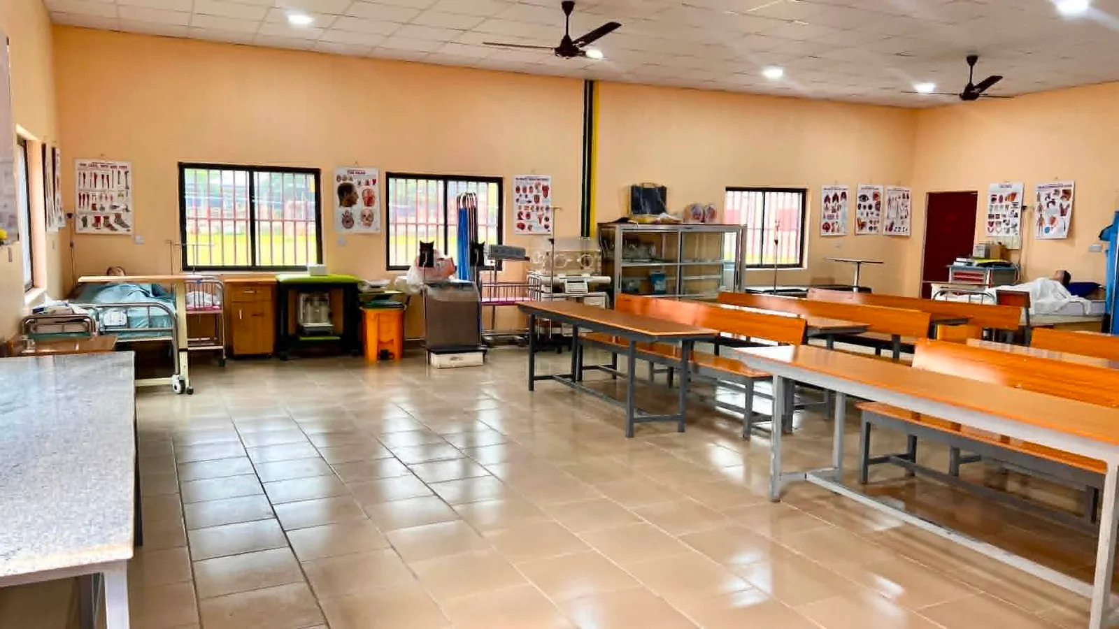 The simulation and demonstration hall, with hospital beds, an incubator and anatomy charts along the walls