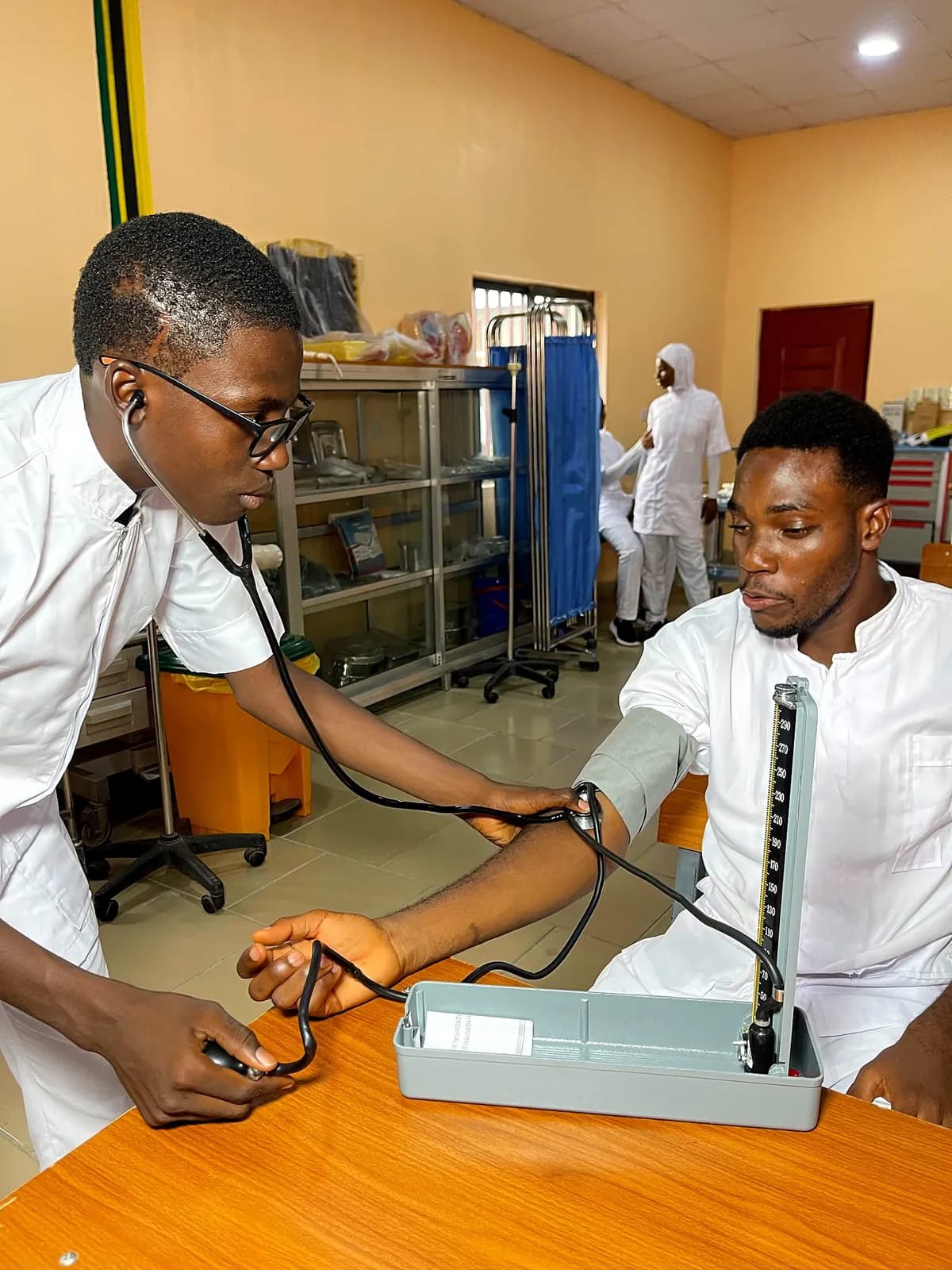 Student nurse taking a classmate's blood pressure
