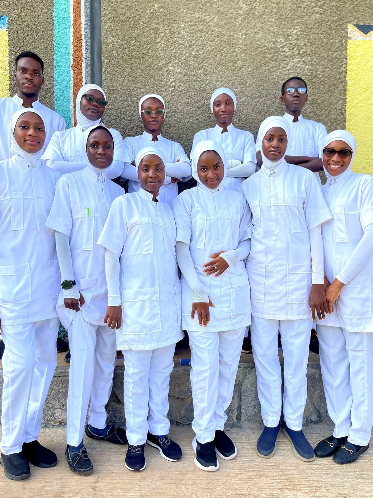 A cohort of Almadina College student nurses standing together in white uniform