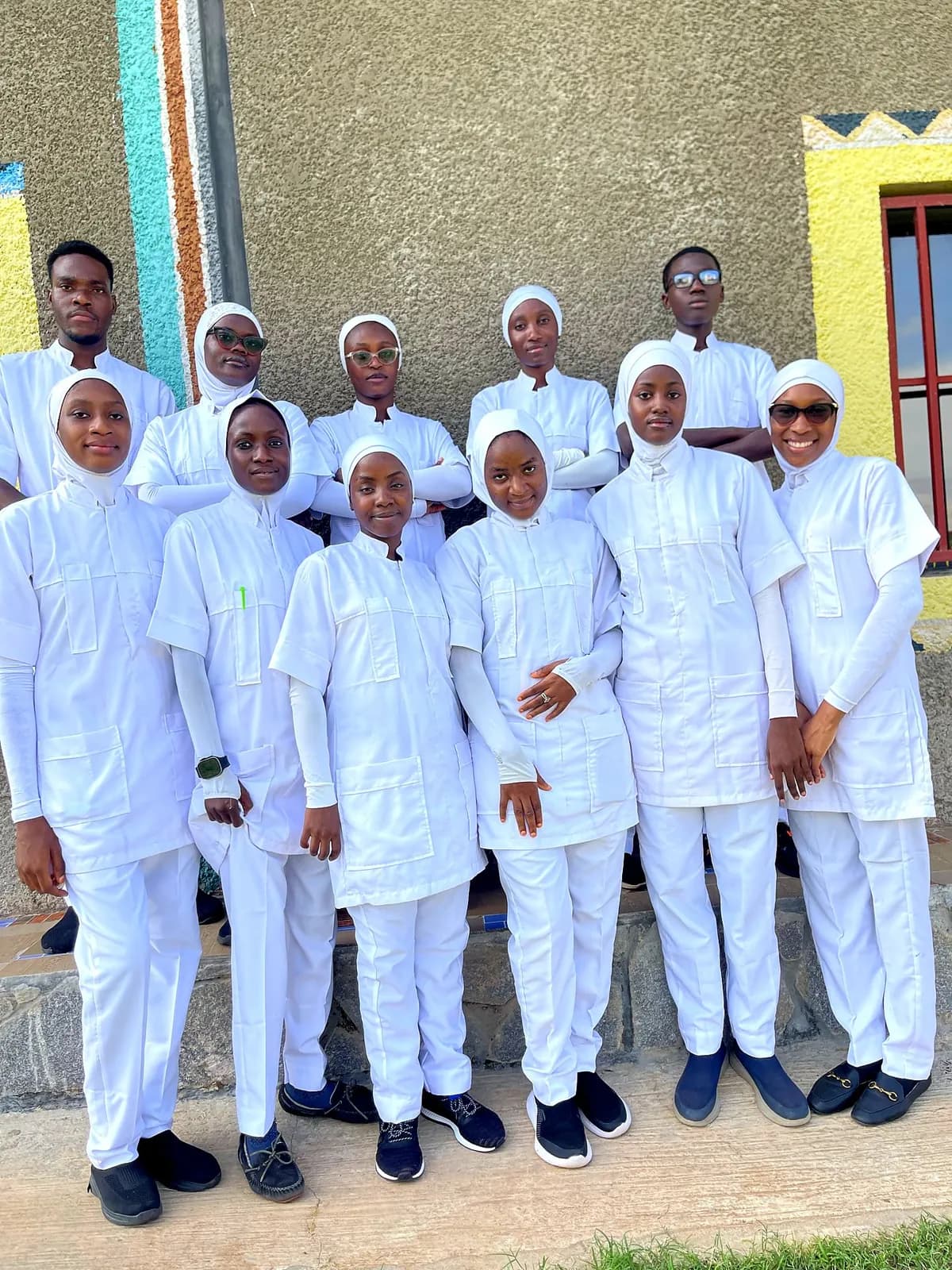 Almadina College student nurses in white clinical uniform outside the college block