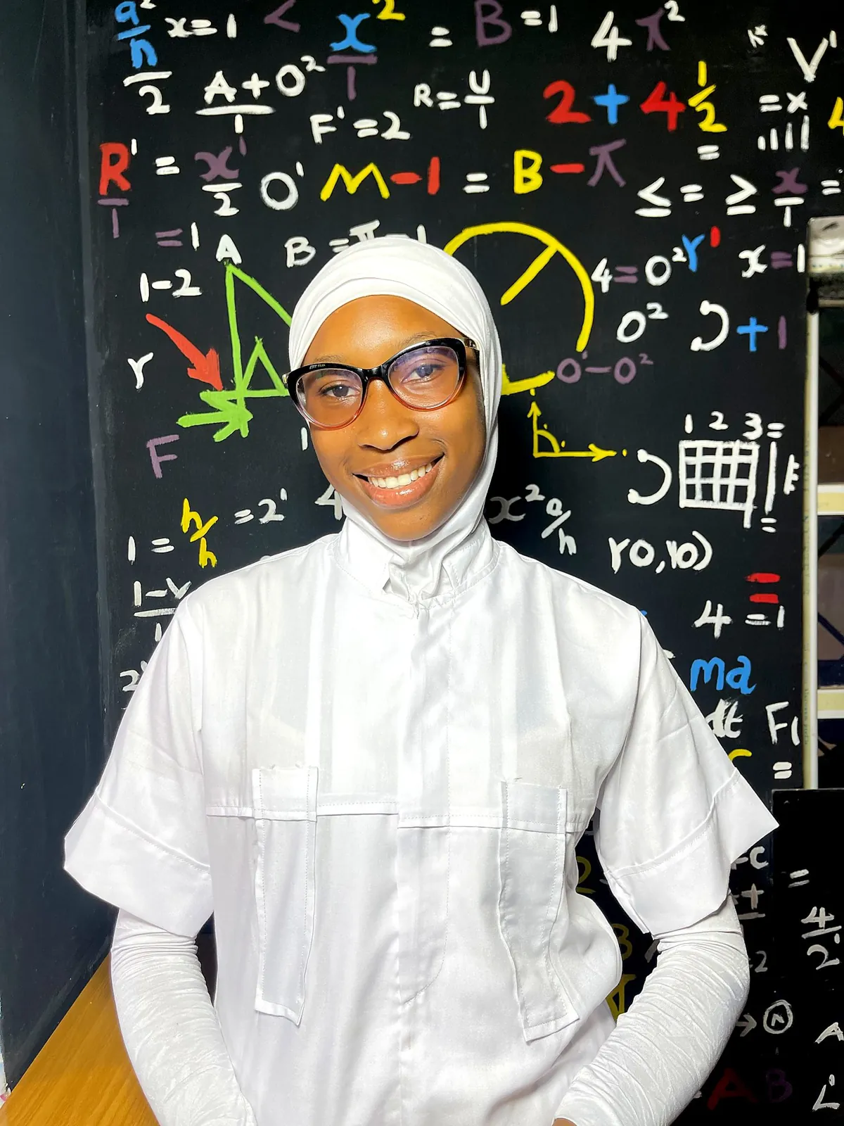 Smiling student nurse in front of a chalkboard